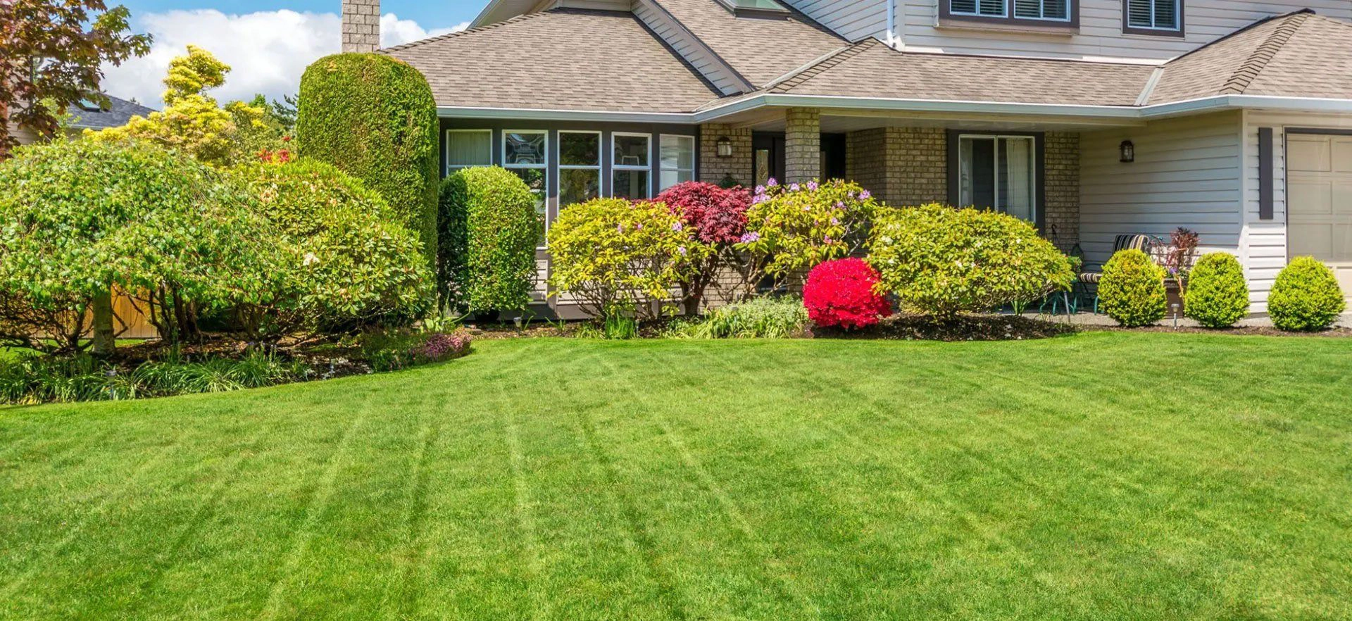 Freshly landscaped home yard with mowed lawn